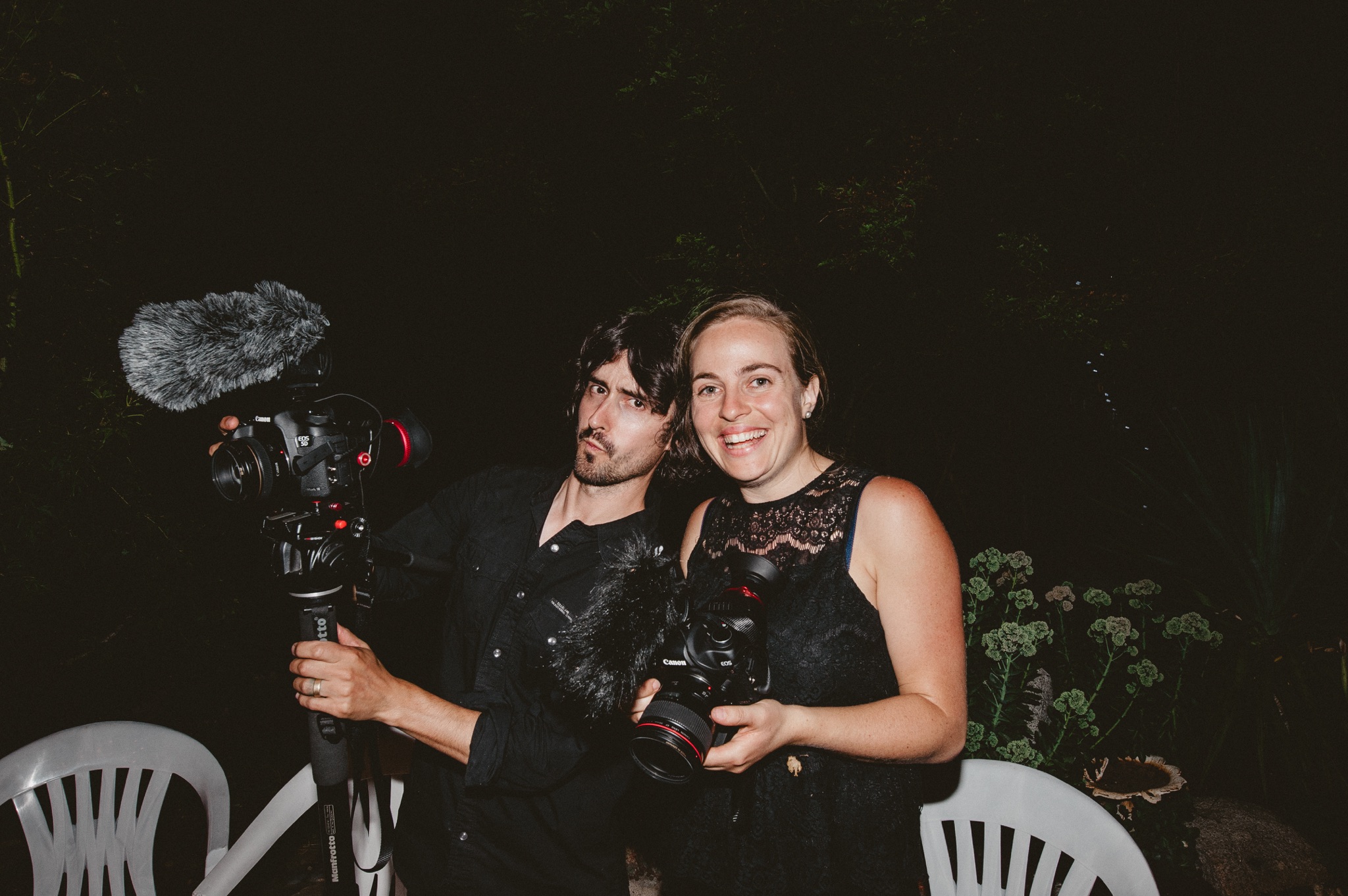 Melissa and Jim with their cameras filming a wedding video.