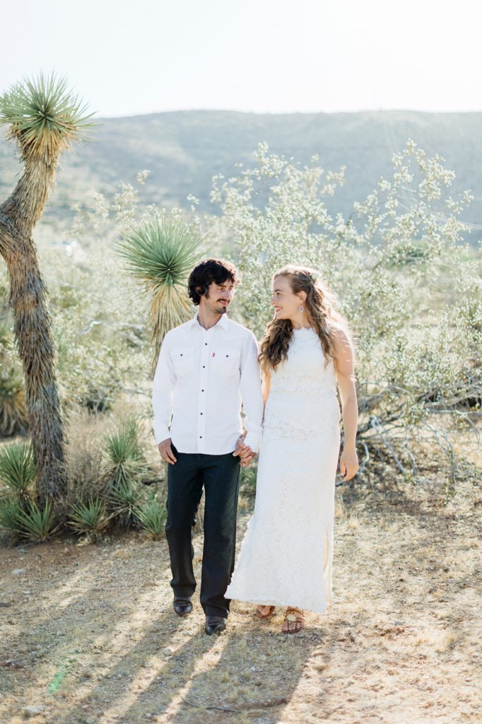 Jim and Melissa dressed for their wedding standing by a Joshua Tree